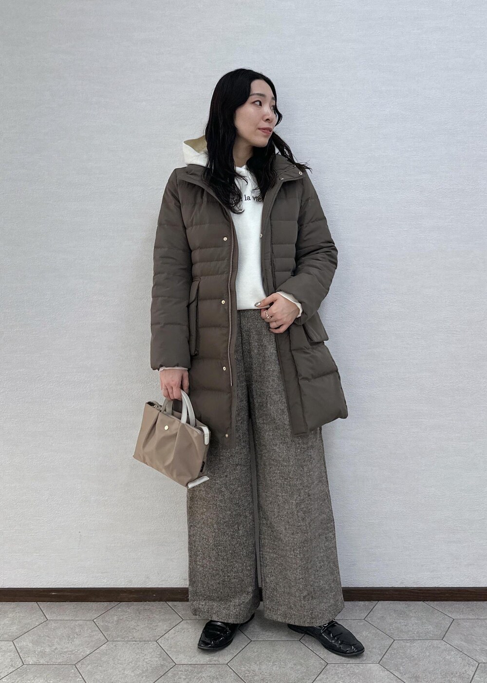 ブラウン系のダウンジャケット/コート、ブラウン系のその他パンツ、ブラウン系のショルダーバッグを着用したレディースの冬コーディネートの4枚目の写真