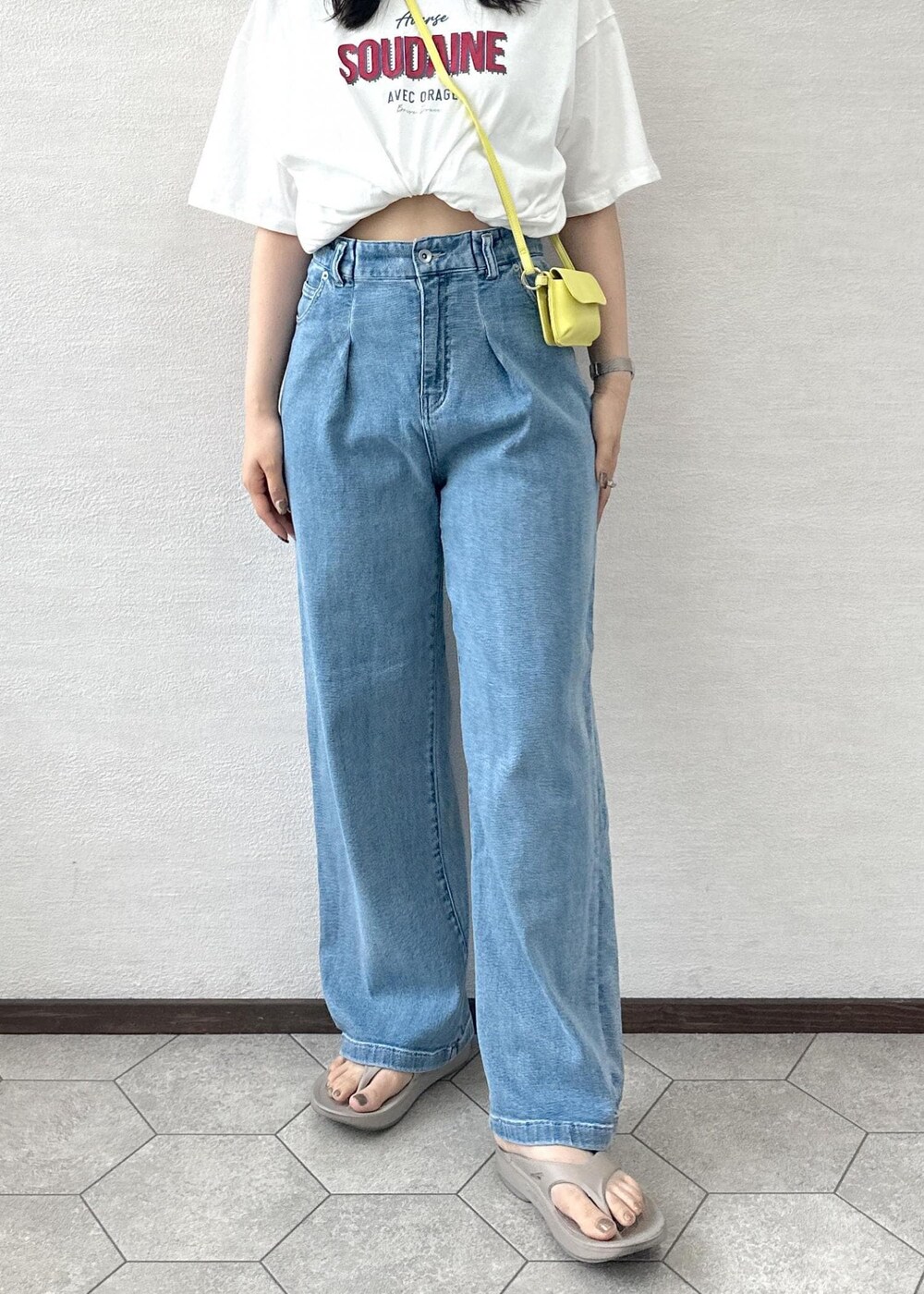 イエロー系のショルダーバッグ、ブルー系のデニムパンツ、ホワイト系のTシャツ/カットソーを着用したレディースの夏コーディネートの6枚目の写真