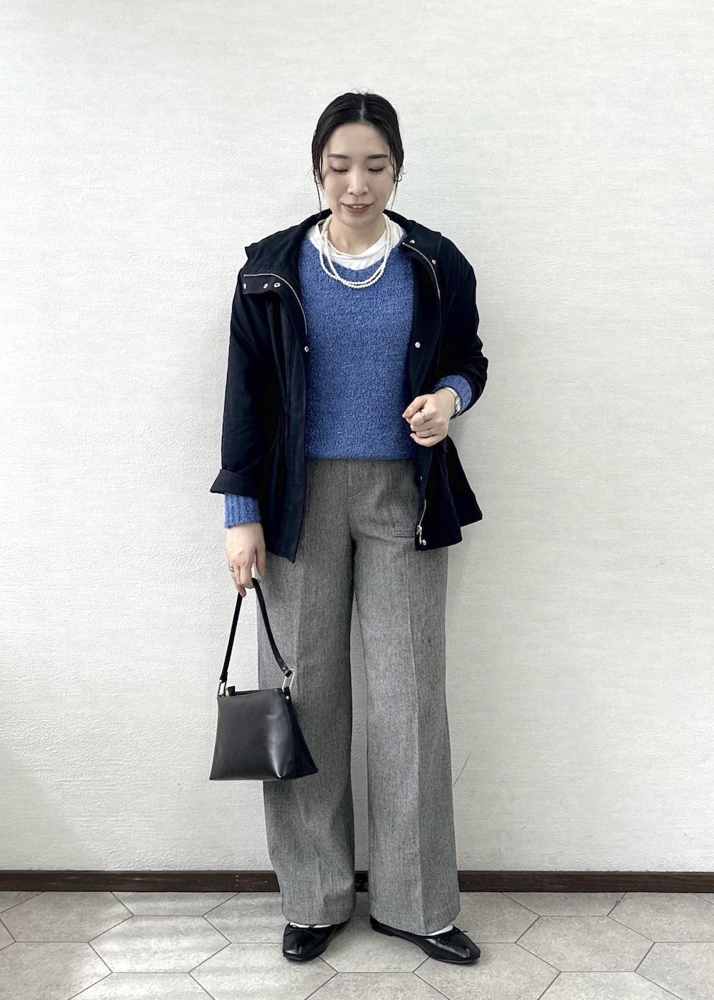 ブラック系のショルダーバッグ、ブルー系のニット/セーター、グレー系のその他パンツを着用したレディースの春コーディネートの3枚目の写真