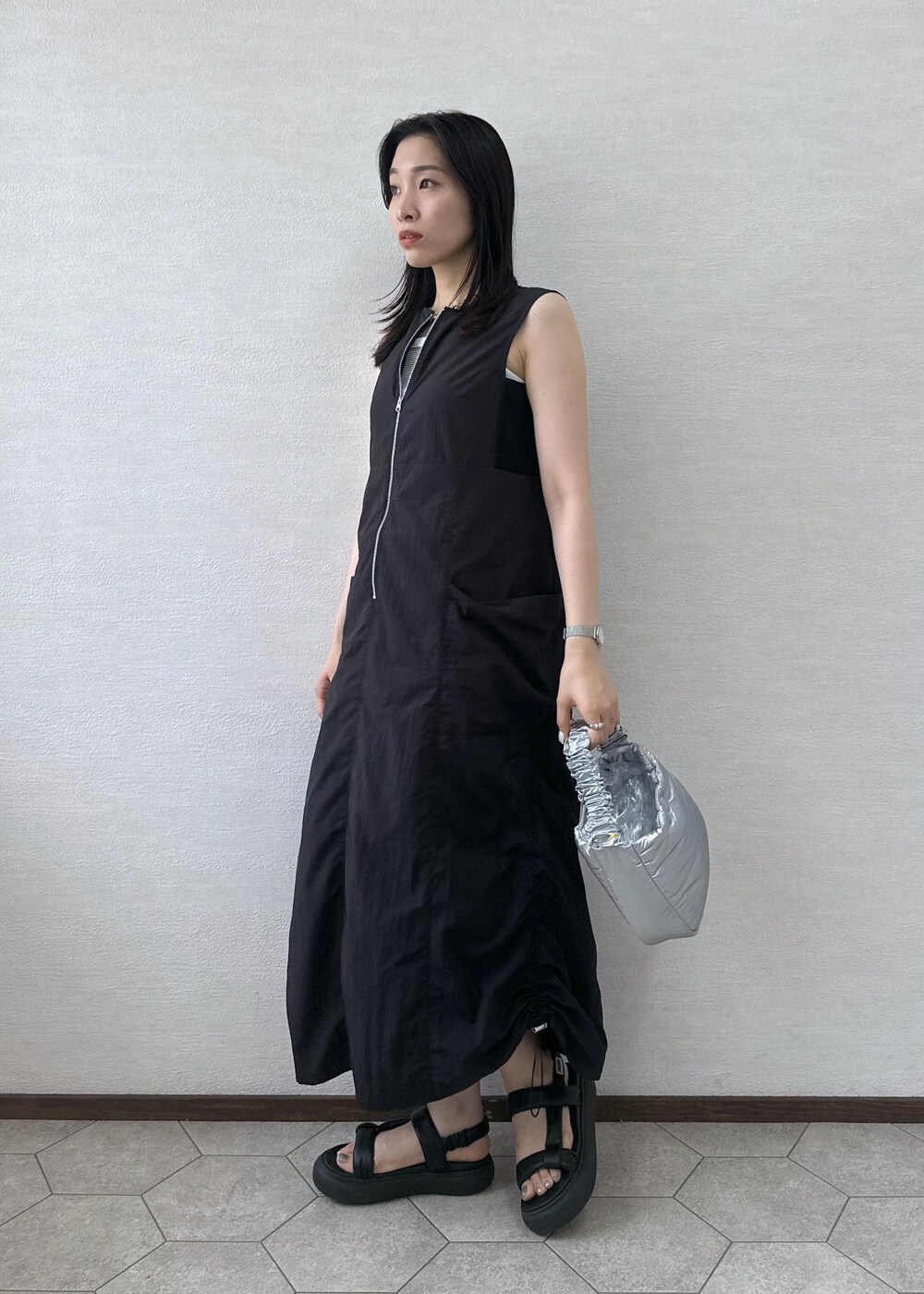 ブラック系のワンピース、シルバー系のショルダーバッグを着用したレディースの夏コーディネートの4枚目の写真