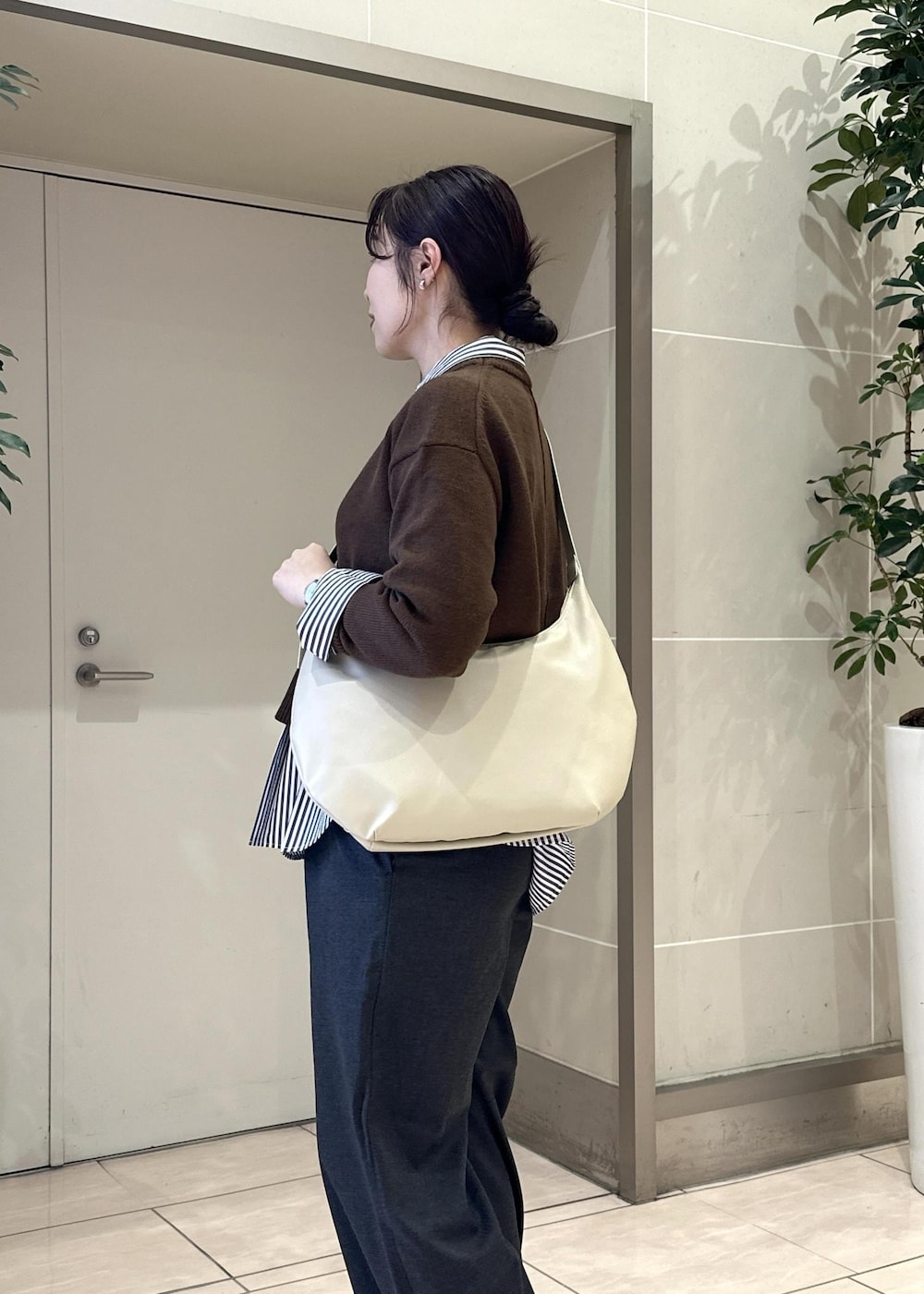 グレー系のその他パンツ、ブルー系のシャツ/ブラウス、ホワイト系のスニーカーを着用したレディースの冬コーディネートの7枚目の写真