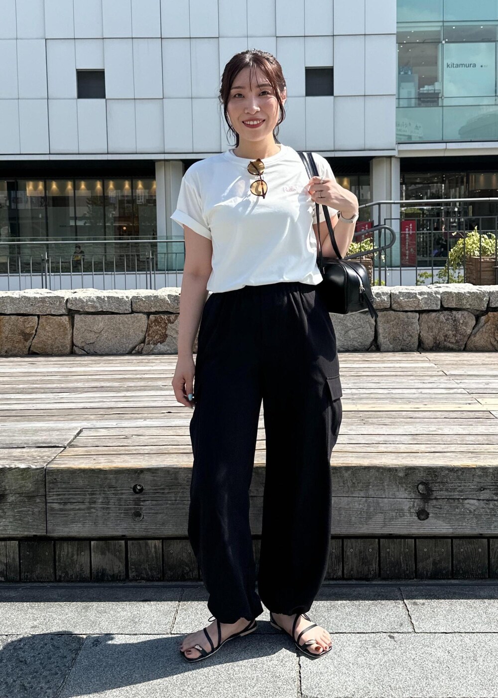 ブラック系のカーゴパンツ、ブラック系のサンダル、ホワイト系のTシャツ/カットソーを着用したレディースの夏コーディネートの4枚目の写真