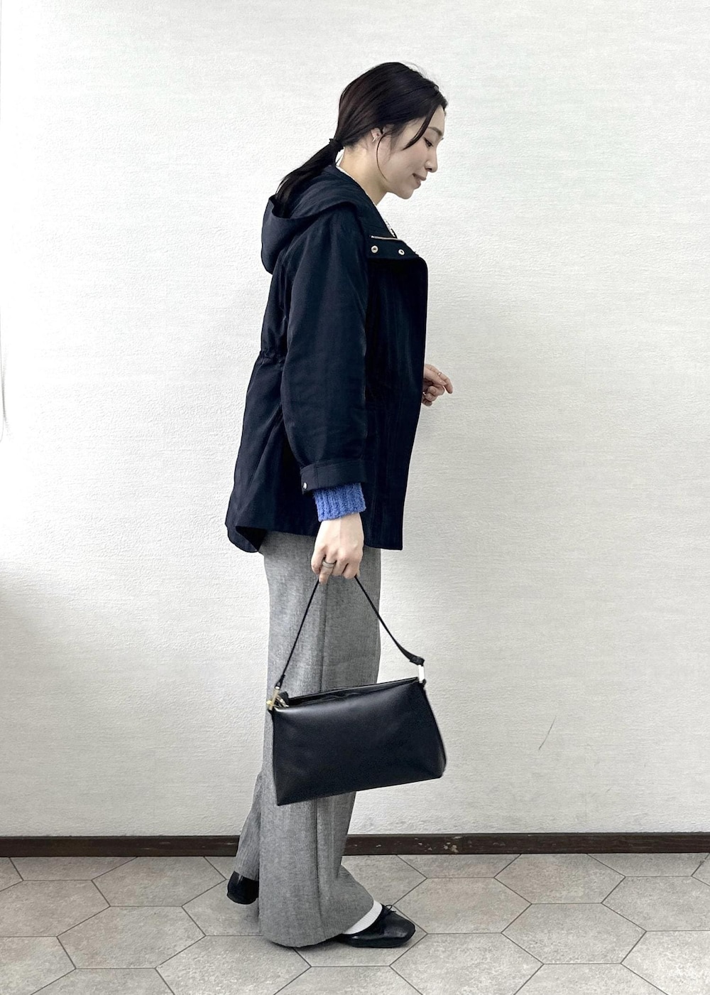 ブラック系のショルダーバッグ、ブルー系のニット/セーター、グレー系のその他パンツを着用したレディースの春コーディネートの4枚目の写真