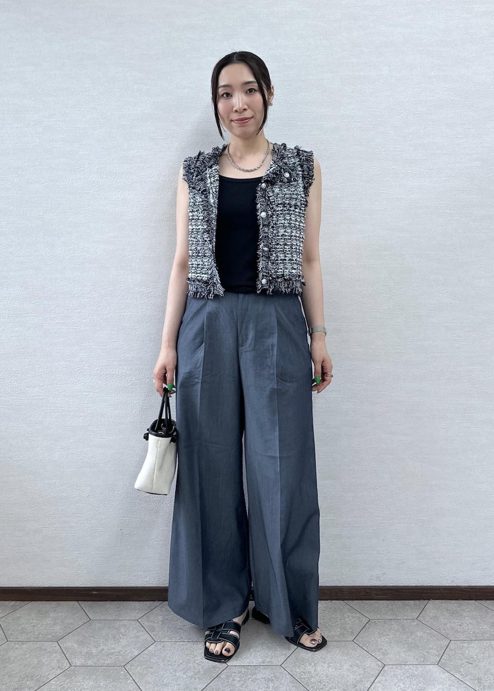ブラック系のトートバッグ、ブラック系のカーディガン/ボレロ、ブルー系のその他パンツを着用したレディースの夏コーディネートの3枚目の写真