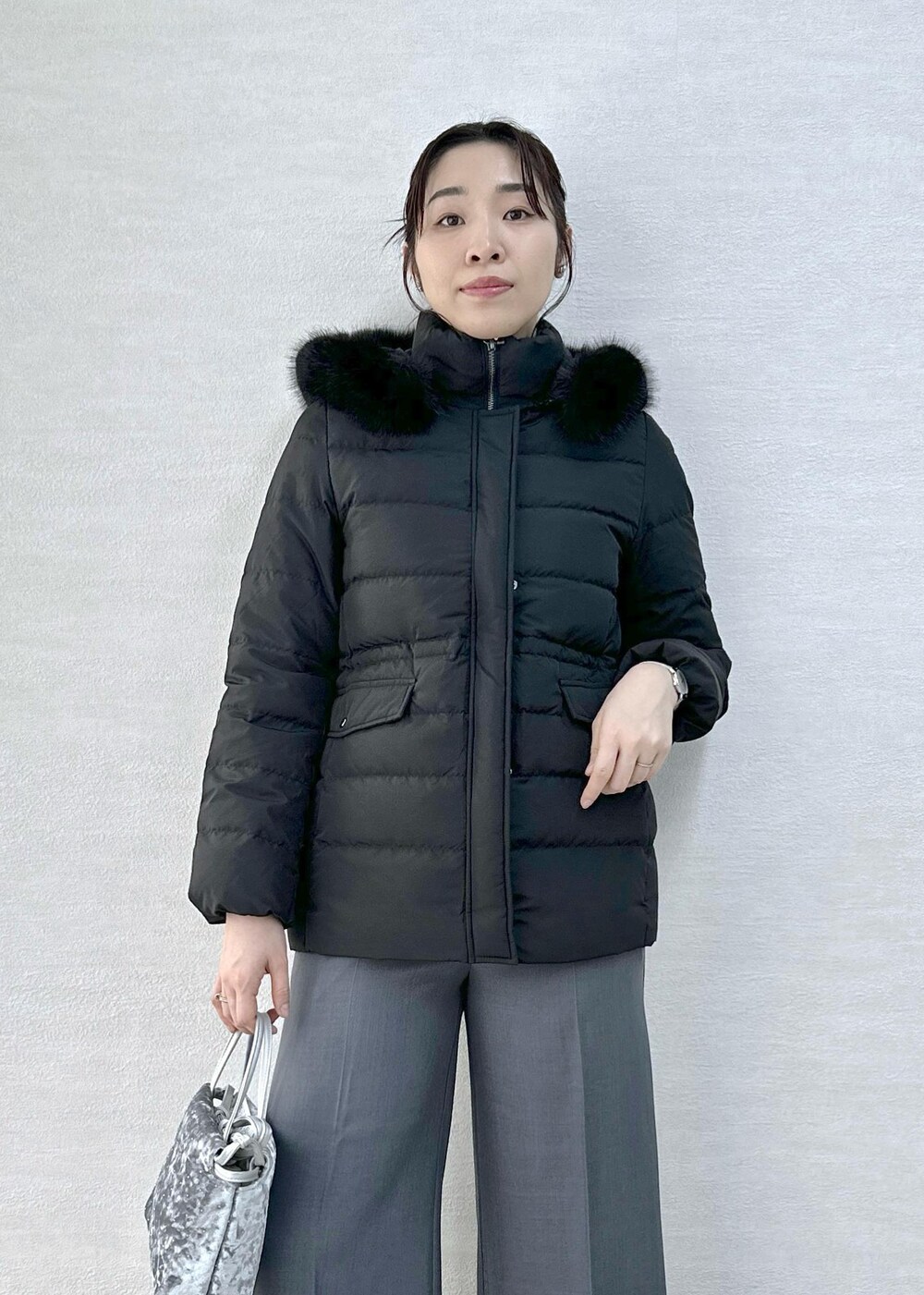 グレー系のその他パンツ、ブルー系のカーディガン/ボレロ、ブラック系のダウンジャケット/コートを着用したレディースの冬コーディネートの8枚目の写真
