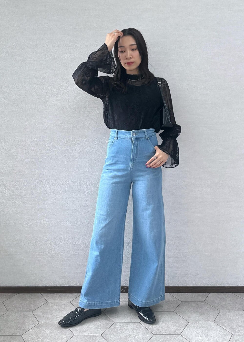 ブルー系のデニムパンツ、ブラック系のショルダーバッグ、ブラック系のシャツ/ブラウスを着用したレディースの秋コーディネートの2枚目の写真