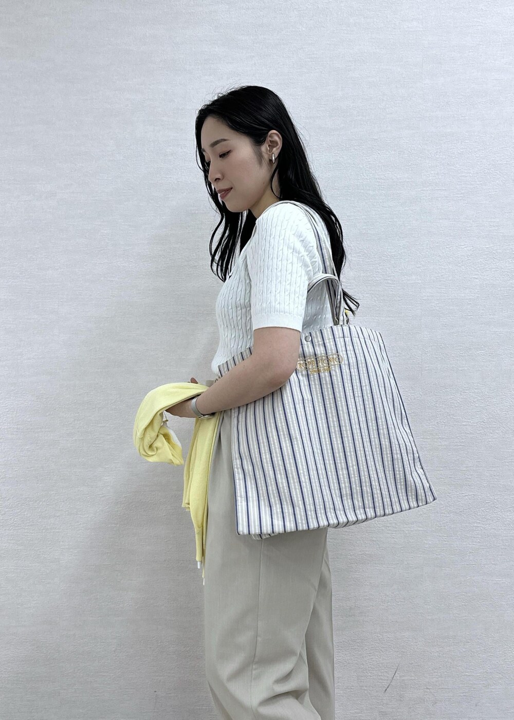 ベージュ系のトートバッグ、ベージュ系のその他パンツ、シルバー系のバレエシューズを着用したレディースの春コーディネートの8枚目の写真