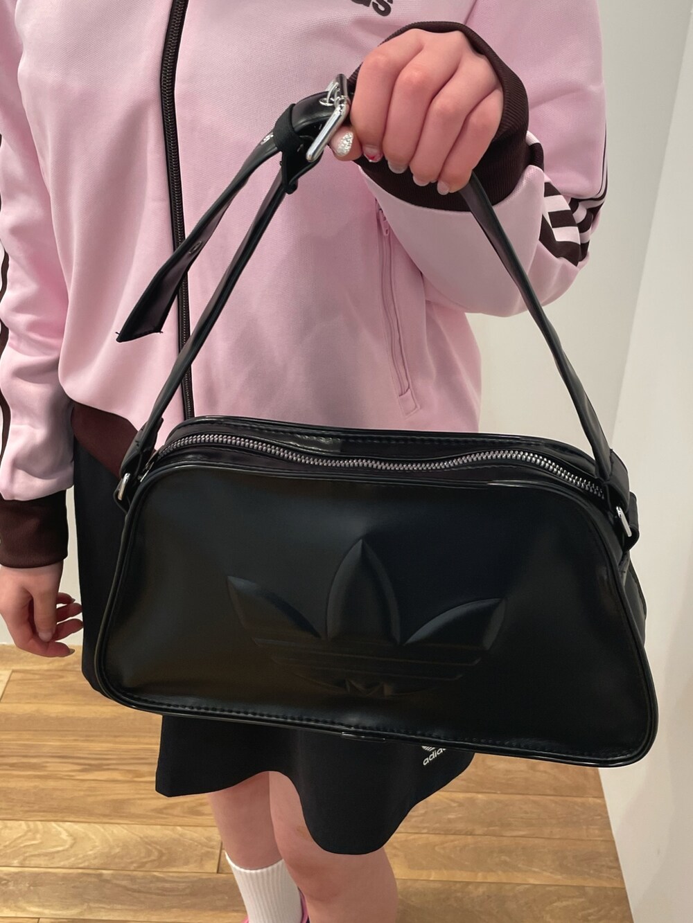 ピンク系のトップス、ブラック系のスカート、ブラック系のショルダーバッグを着用したレディースの冬コーディネートの4枚目の写真