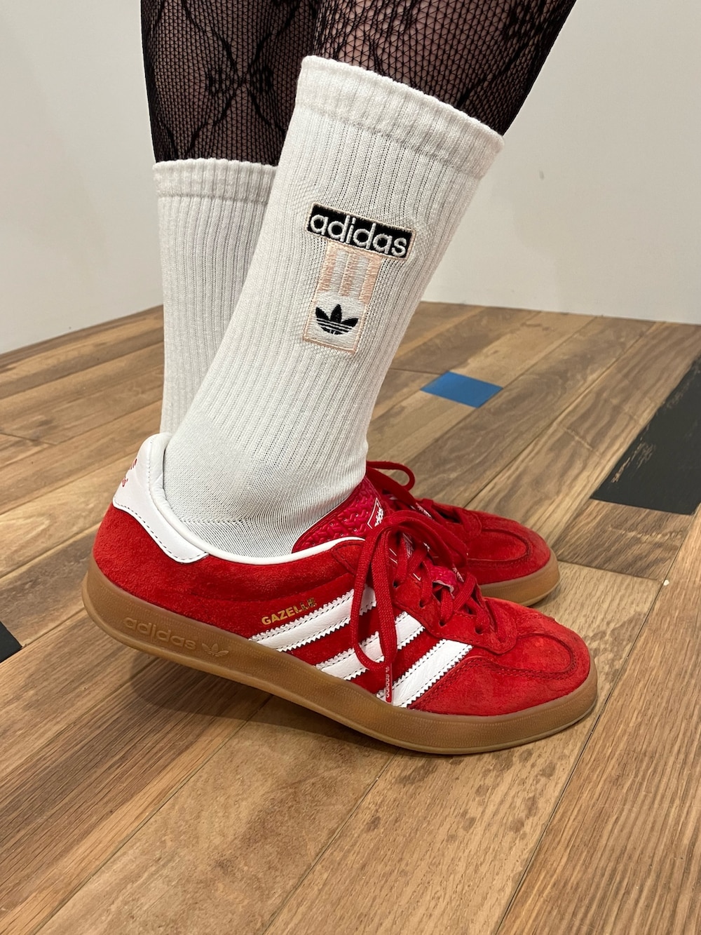 レッド系のジャージ、ブラック系のショルダーバッグ、レッド系のスニーカーを着用したレディースの冬コーディネートの4枚目の写真