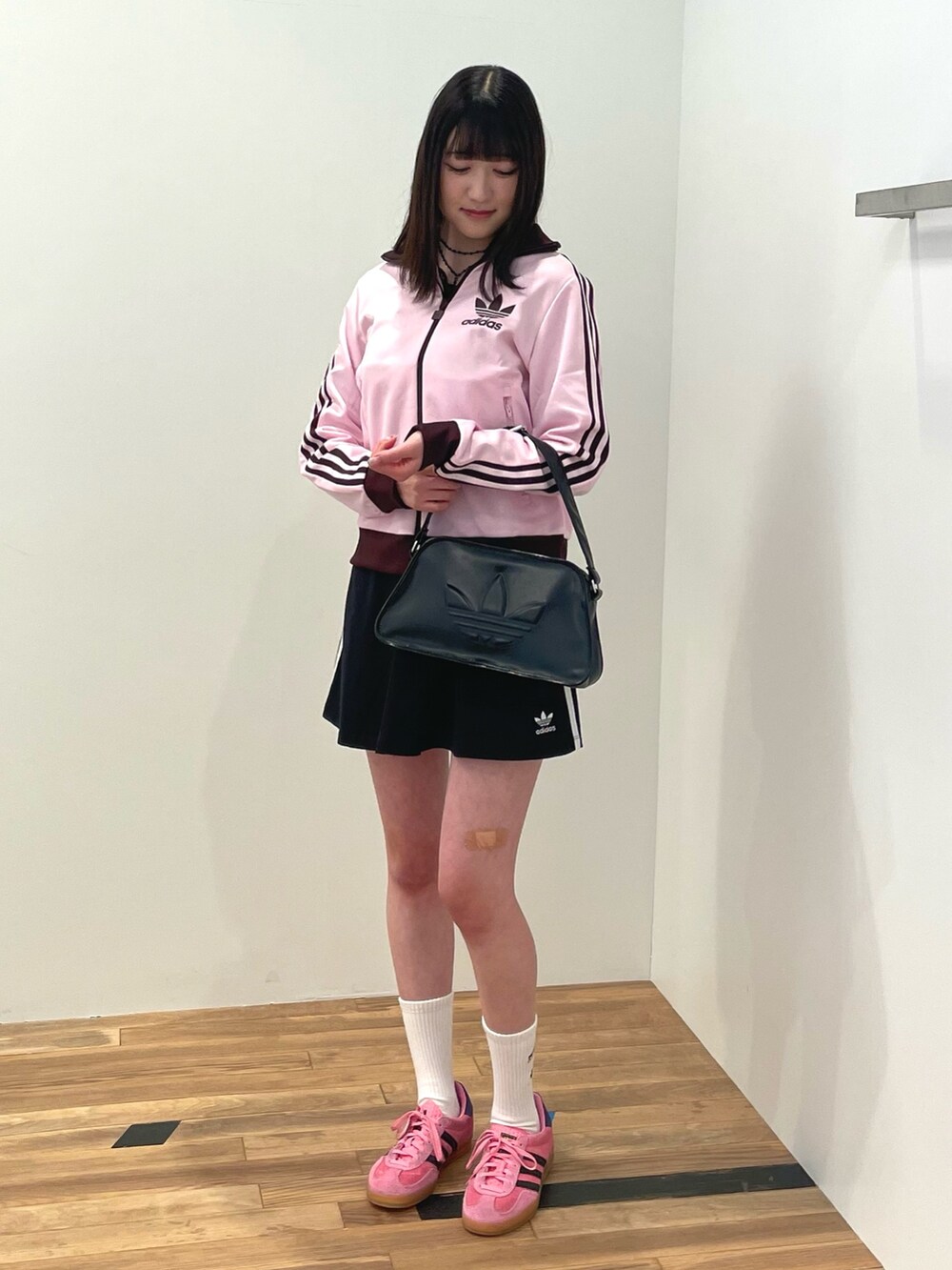 ピンク系のトップス、ブラック系のスカート、ブラック系のショルダーバッグを着用したレディースの冬コーディネートの2枚目の写真