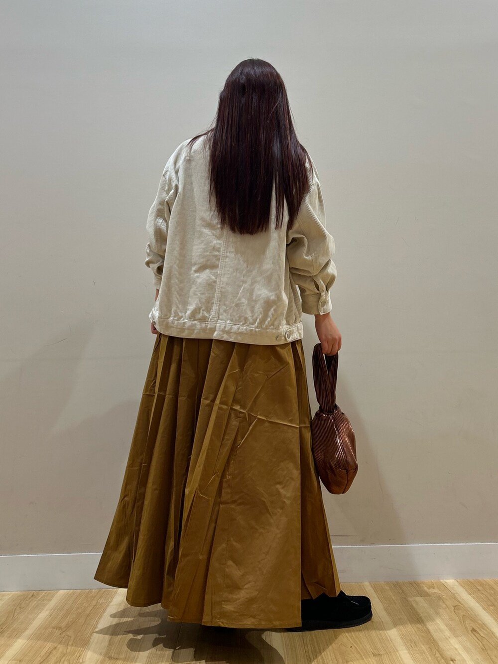 ホワイト系のノーカラージャケット、ホワイト系のTシャツ/カットソー、イエロー系のスカートを着用したレディースの秋コーディネートの3枚目の写真