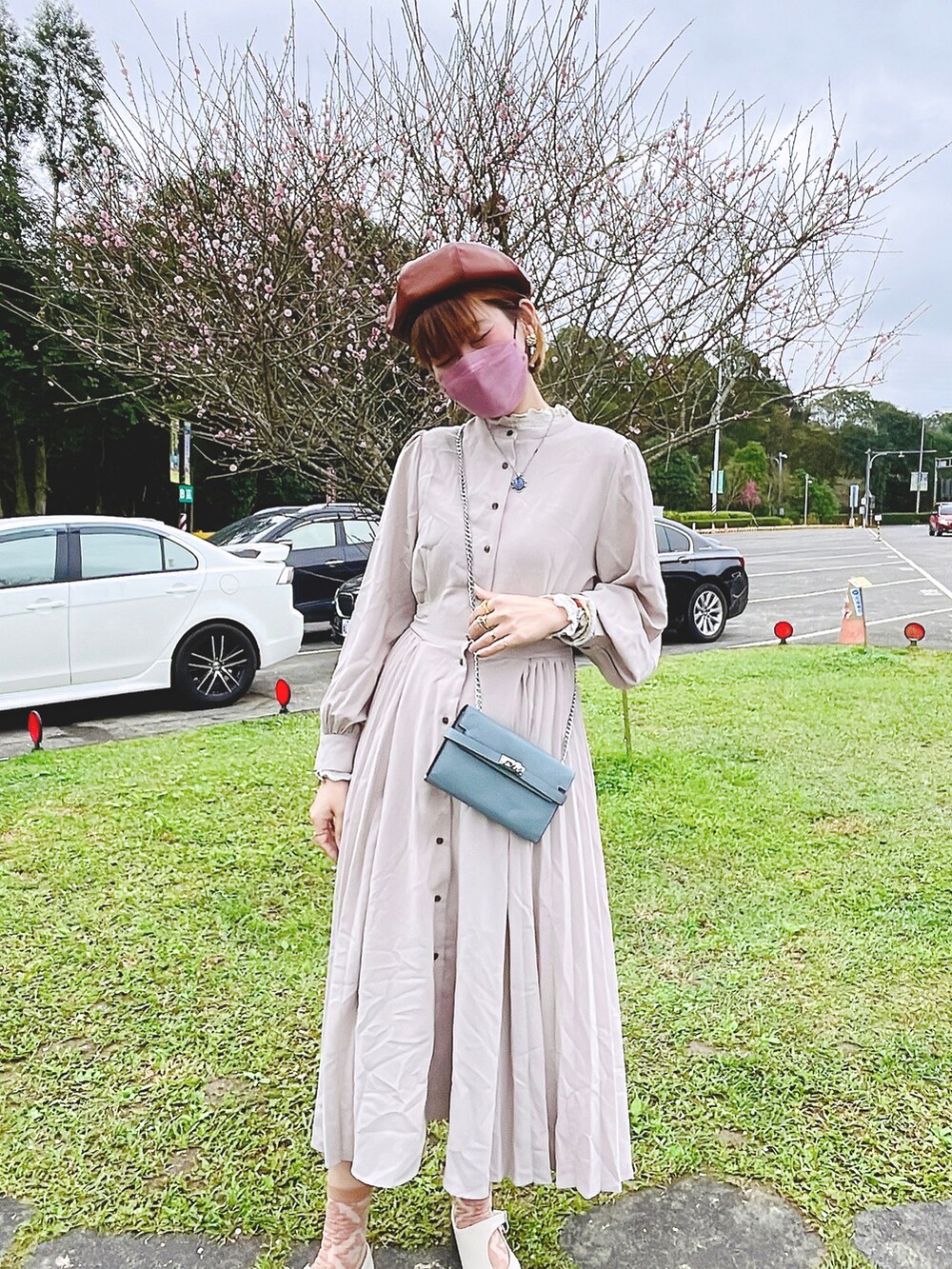 ベージュ系のトレンチコート、グレー系のワンピースを着用したレディースの冬コーディネートの3枚目の写真