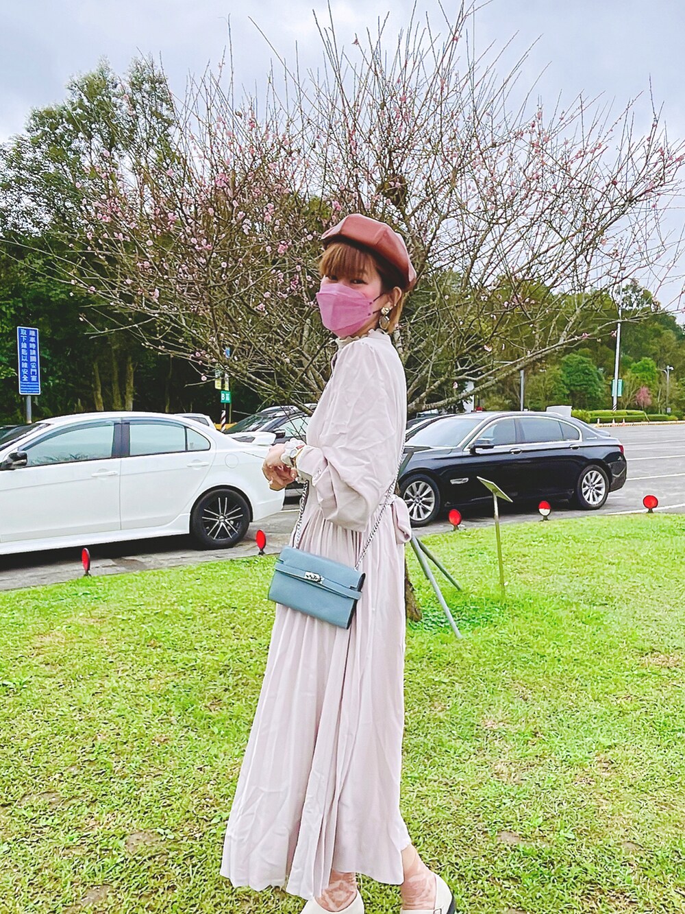 ベージュ系のトレンチコート、グレー系のワンピースを着用したレディースの冬コーディネートの4枚目の写真