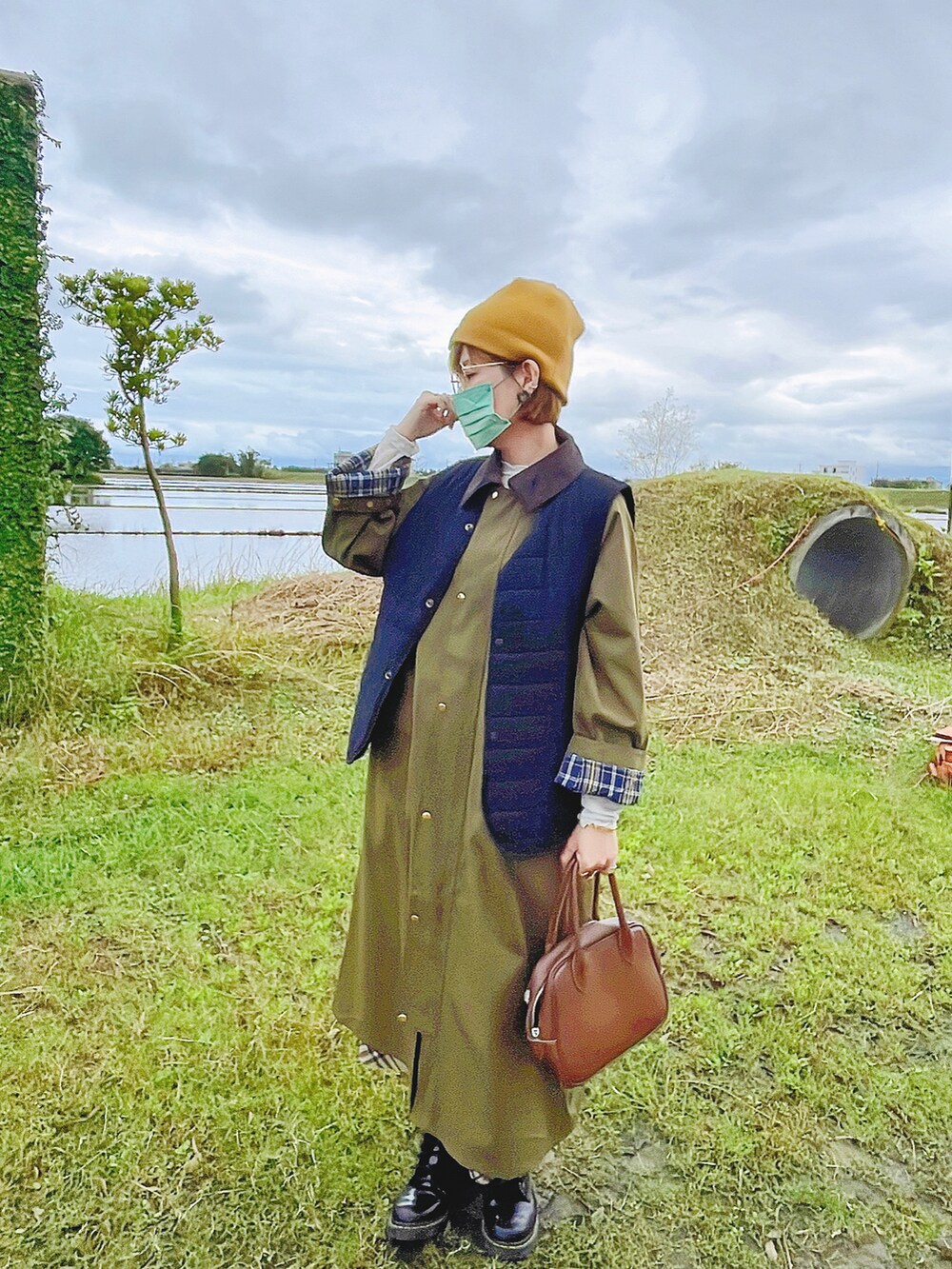 ブラック系のブーツ、イエロー系のニットキャップ/ビーニーを着用したレディースの冬コーディネートの2枚目の写真