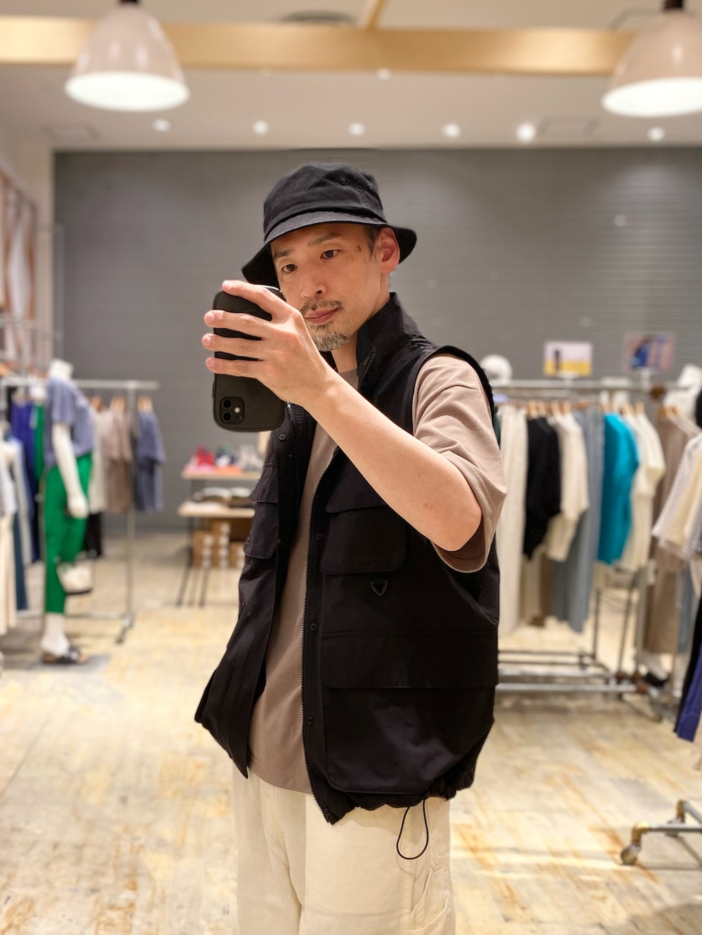 ブラック系のその他アウター、ベージュ系のTシャツ/カットソー、ホワイト系のその他パンツを着用したメンズの春コーディネートの3枚目の写真