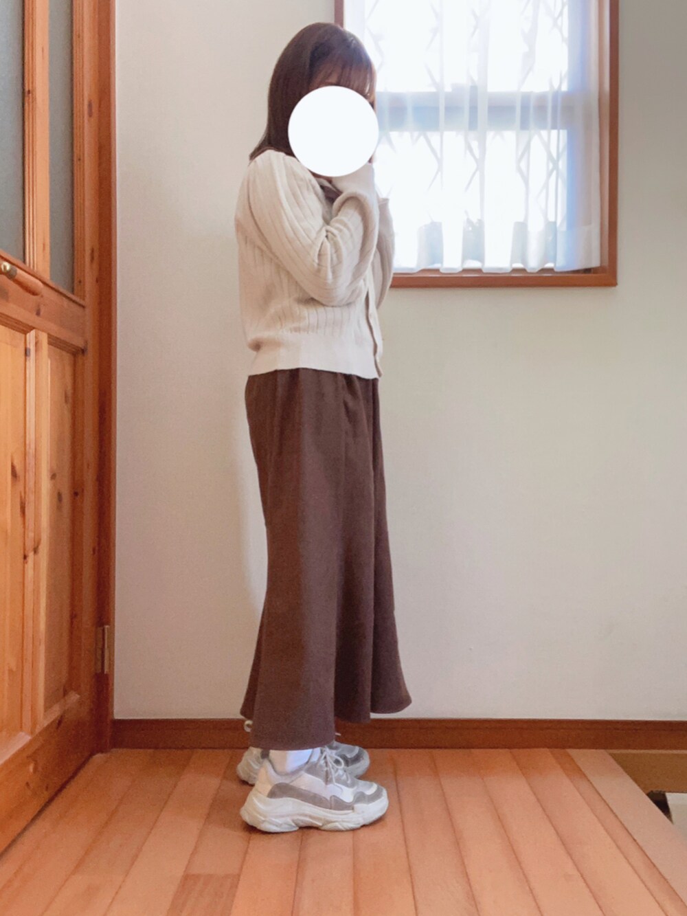 ベージュ系のダウンジャケット/コート、ブラウン系のスカート、ベージュ系のスニーカーを着用したレディースの冬コーディネートの2枚目の写真