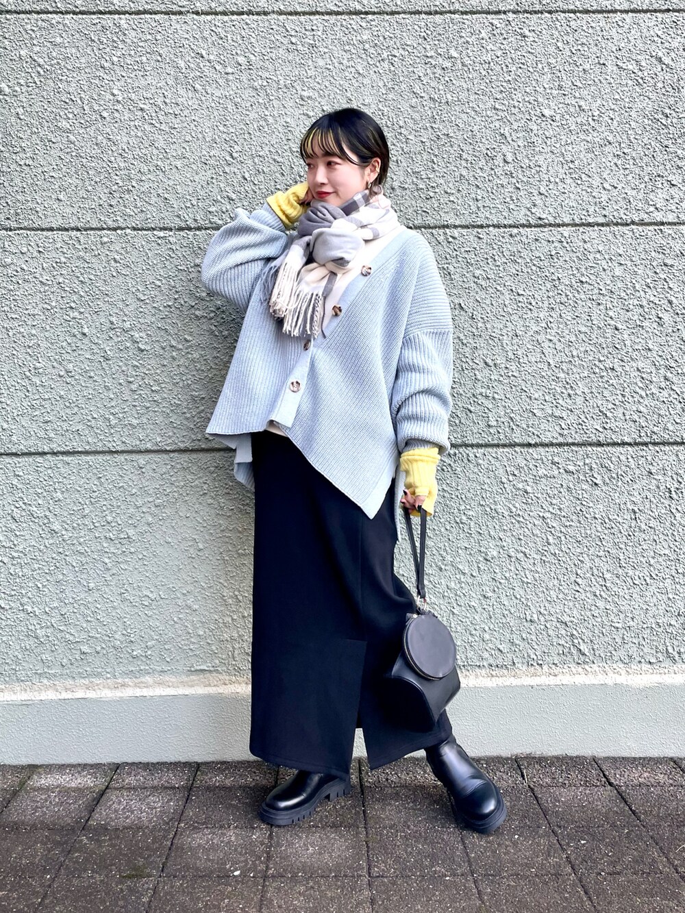 ブルー系のカーディガン/ボレロ、ブラック系のスカート、ブラック系のブーツを着用したレディースの秋コーディネートの2枚目の写真