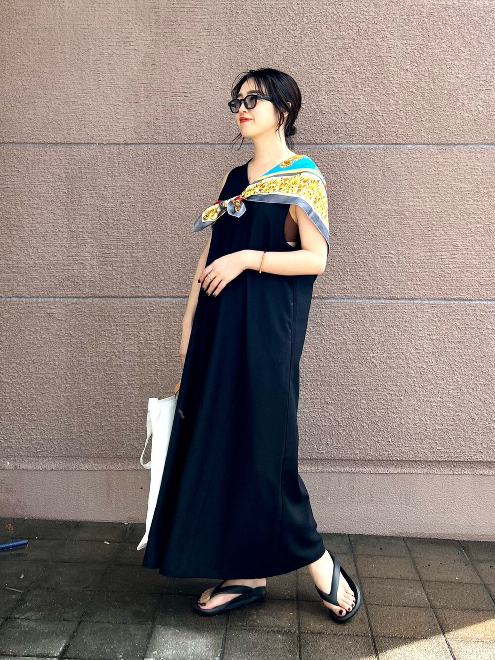 ブラック系のワンピース、ブラック系のサンダル、ブラック系のメガネを着用したレディースの夏コーディネートの2枚目の写真