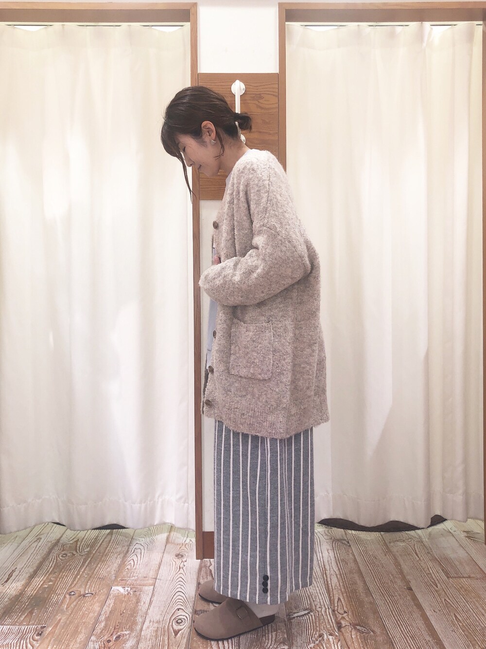 グリーン系のスウェット、ホワイト系のカーディガン/ボレロ、グレー系のその他パンツを着用したレディースの冬コーディネートの2枚目の写真