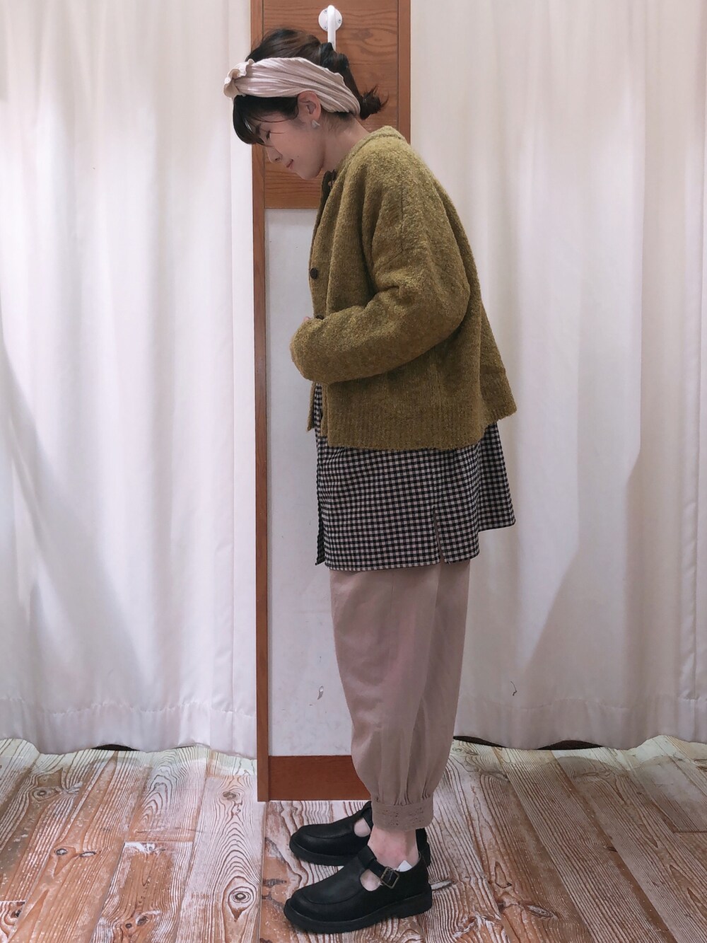 ベージュ系のその他パンツ、グリーン系のカーディガン/ボレロ、ブラック系のチュニックを着用したレディースの秋コーディネートの2枚目の写真