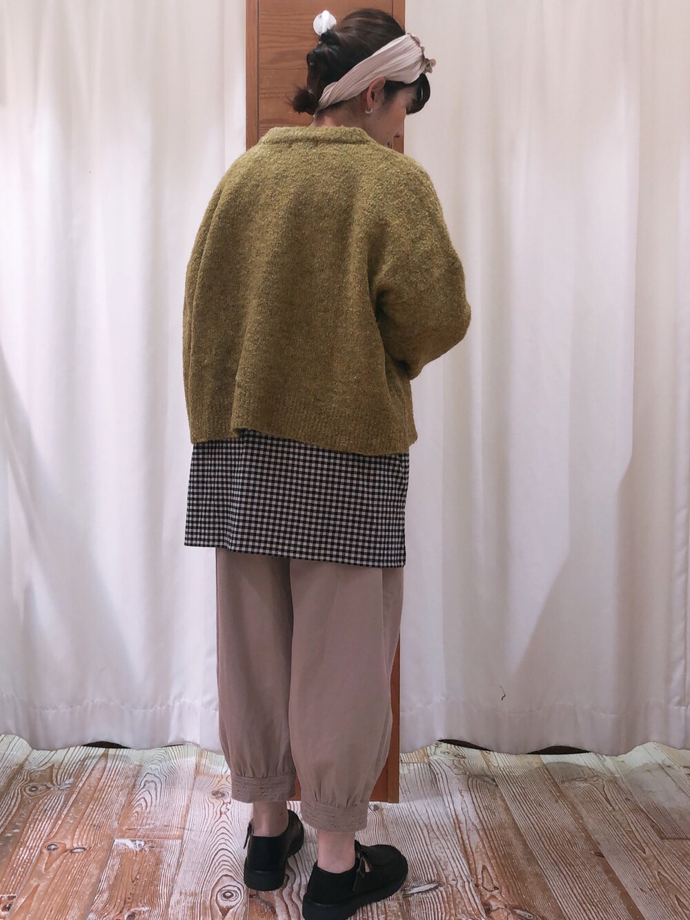 ベージュ系のその他パンツ、グリーン系のカーディガン/ボレロ、ブラック系のチュニックを着用したレディースの秋コーディネートの3枚目の写真