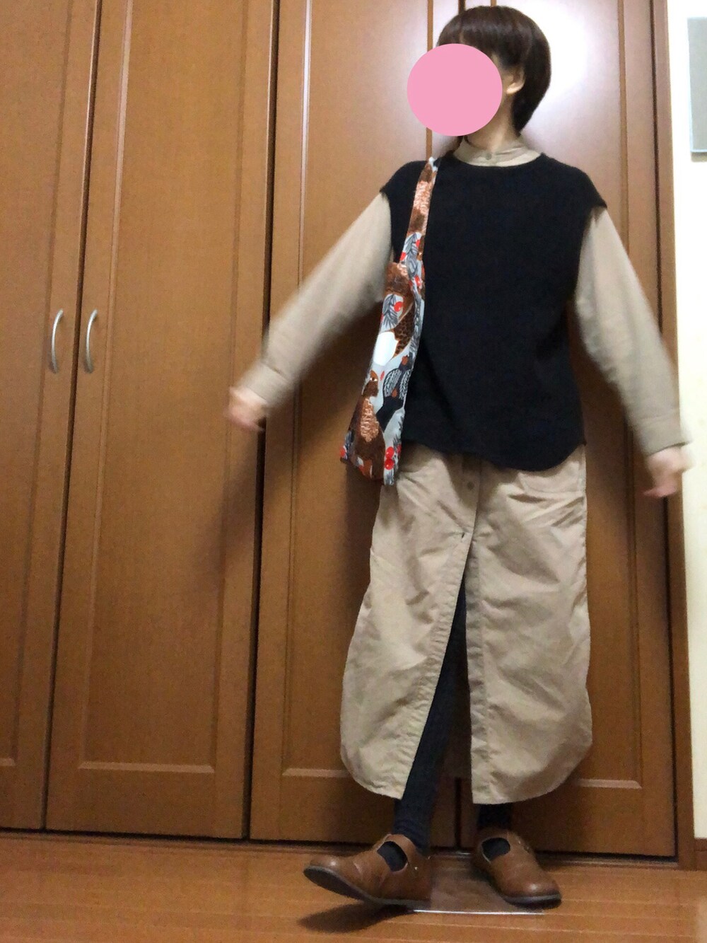 ベージュ系のその他アウター、ブラック系のトップス、ベージュ系のエコバッグ/サブバッグを着用したレディースの秋コーディネートの2枚目の写真