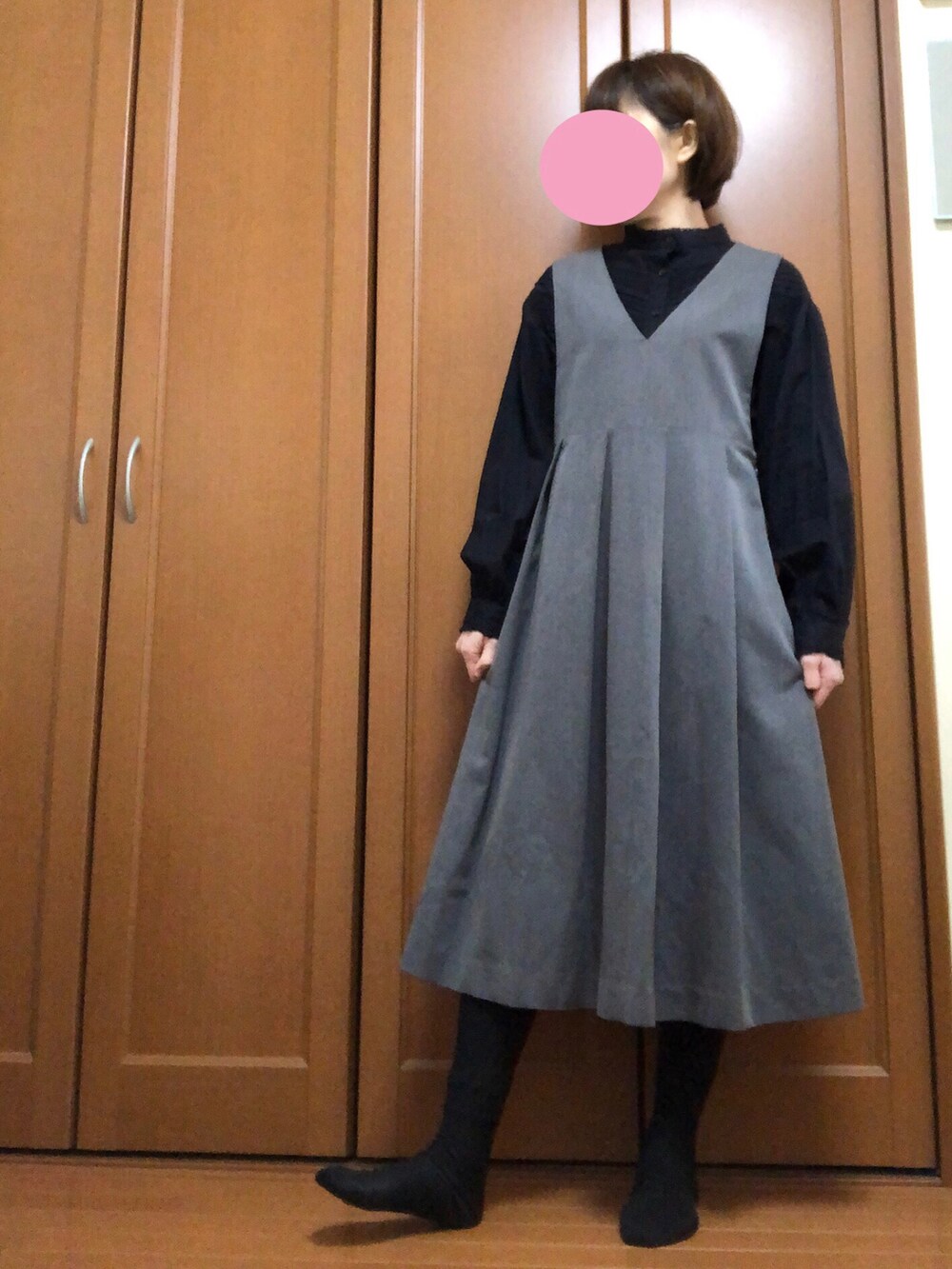 グレー系のジャンパースカート、ブラック系のシャツ/ブラウスを着用したレディースの春コーディネートの2枚目の写真