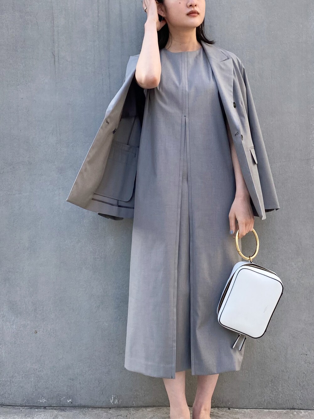 シルバー系のシューズ、ブラック系のワンピース、ブラック系のテーラードジャケットを着用したレディースの春コーディネートの2枚目の写真