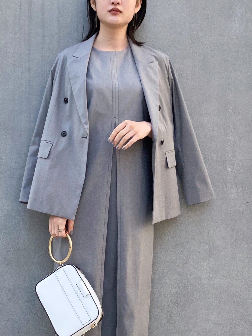 シルバー系のシューズ、ブラック系のワンピース、ブラック系のテーラードジャケットを着用したレディースの春コーディネートの3枚目の写真