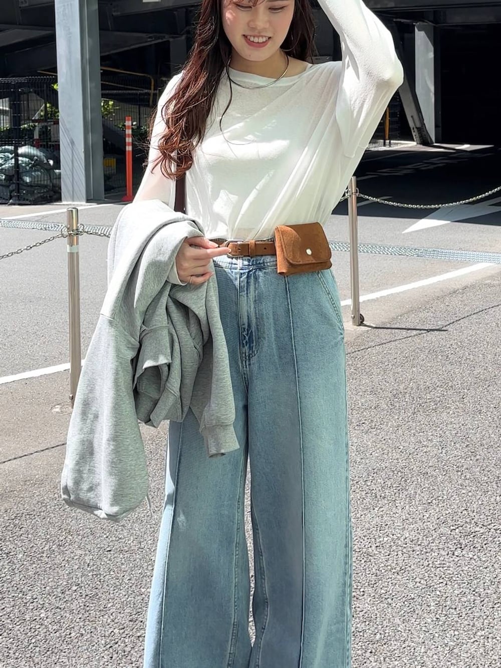 ホワイト系のTシャツ/カットソー、ブラウン系のトートバッグ、ブルー系のデニムパンツを着用したレディースの春コーディネートの6枚目の写真