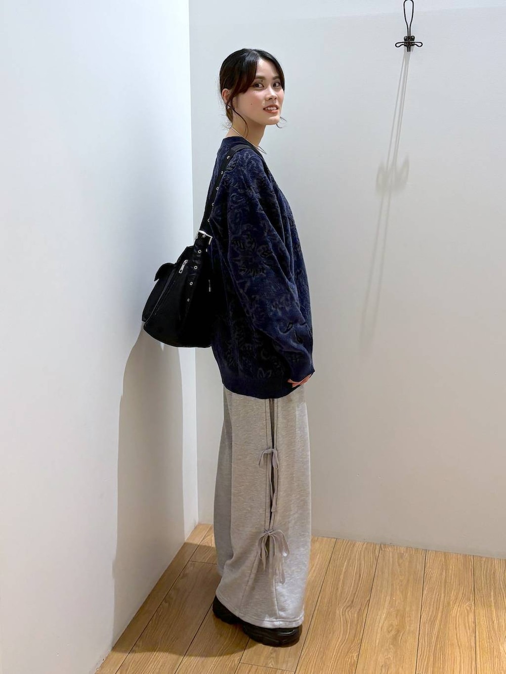 ブラック系のスニーカー、ブラック系のショルダーバッグ、グレー系のスウェットパンツを着用したレディースの秋コーディネートの5枚目の写真