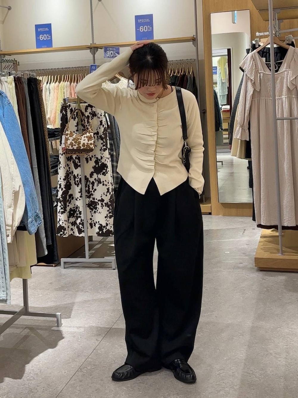 ブラック系のスウェットパンツ、ブラック系のショルダーバッグ、ブラック系のローファーを着用したレディースの春コーディネートの3枚目の写真