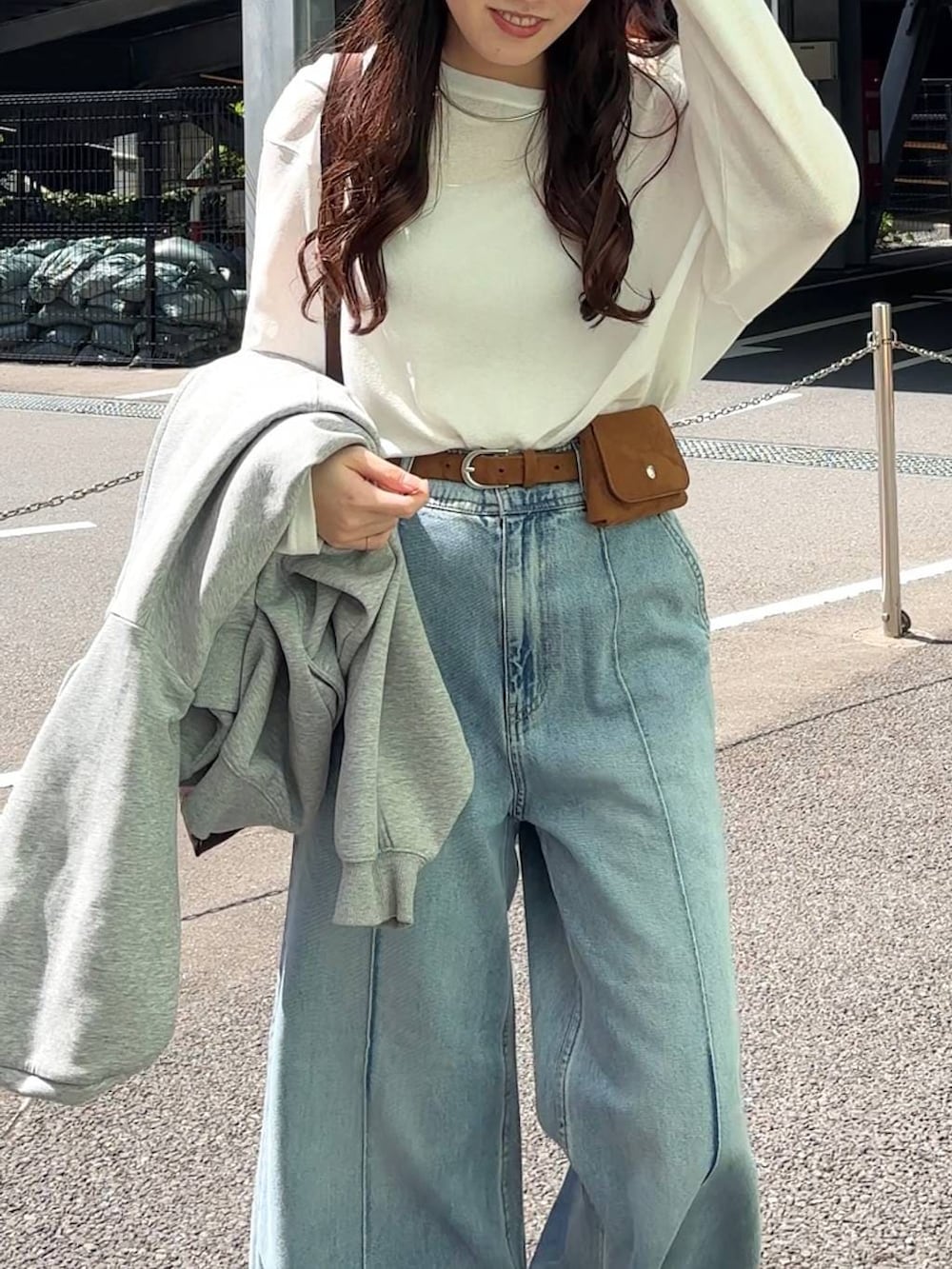 ホワイト系のTシャツ/カットソー、ブラウン系のトートバッグ、ブルー系のデニムパンツを着用したレディースの春コーディネートの8枚目の写真