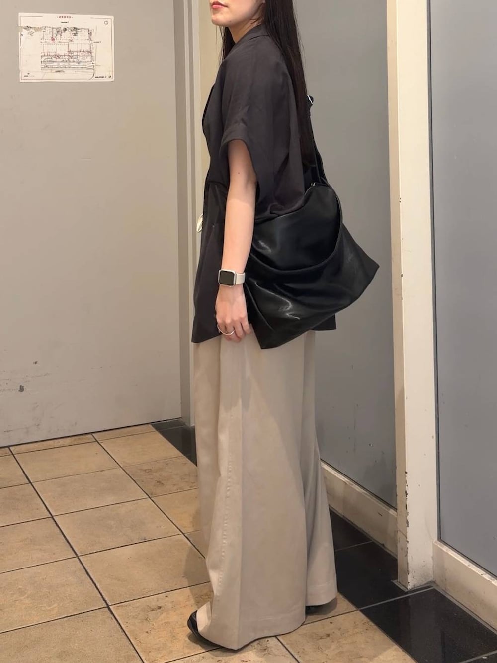 ベージュ系のデニムパンツ、グレー系のテーラードジャケット、ブラック系のショルダーバッグを着用したレディースの夏コーディネートの5枚目の写真