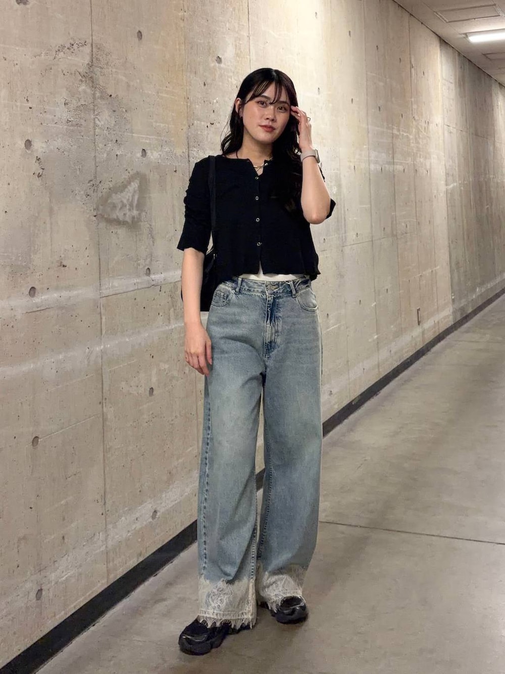 ブルー系のデニムパンツ、ブラック系のTシャツ/カットソー、ブラック系のボストンバッグを着用したレディースの夏コーディネートの5枚目の写真