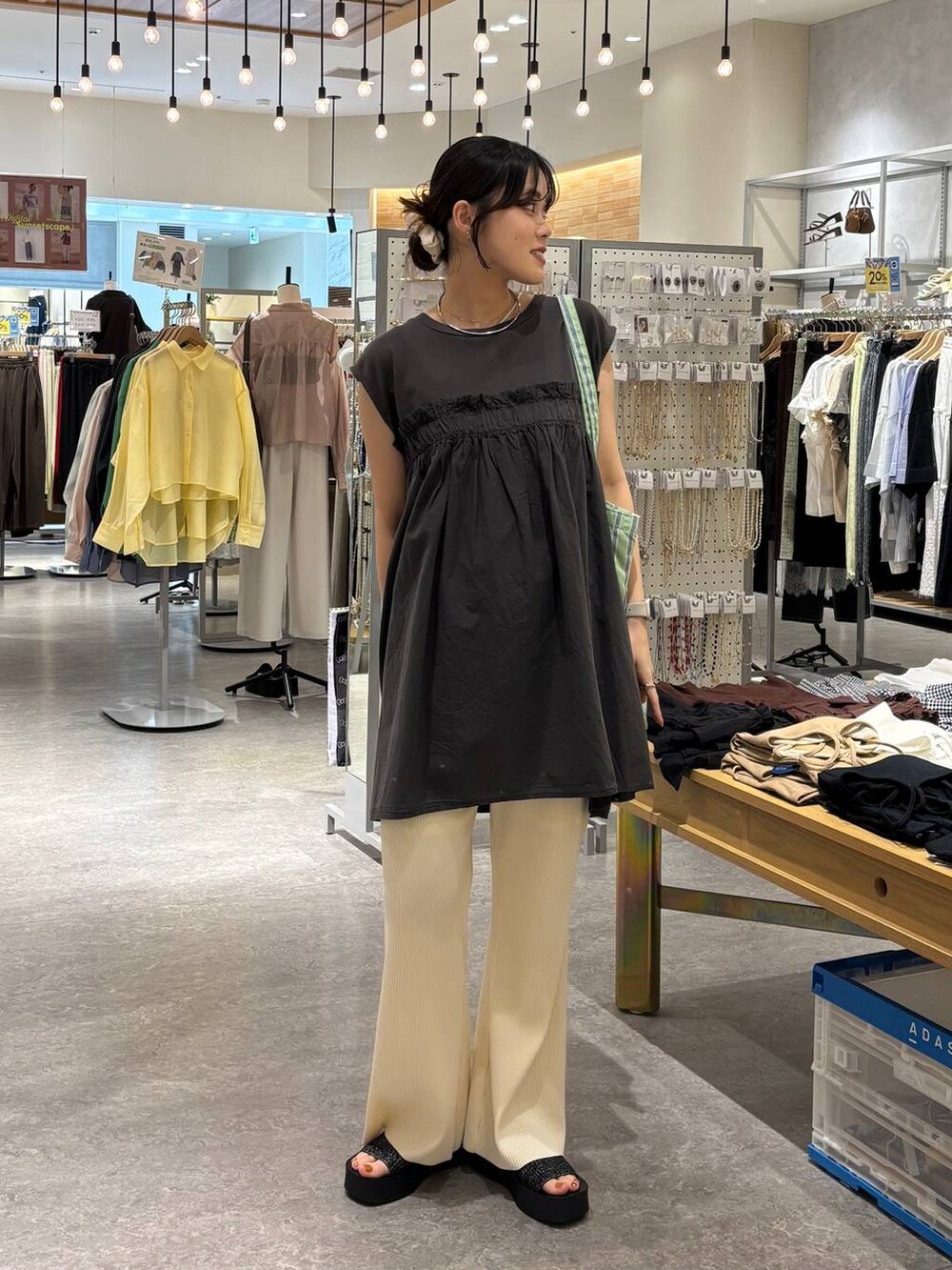 ブラック系のサンダル、その他のトートバッグ、ベージュ系のその他パンツを着用したレディースの夏コーディネートの2枚目の写真