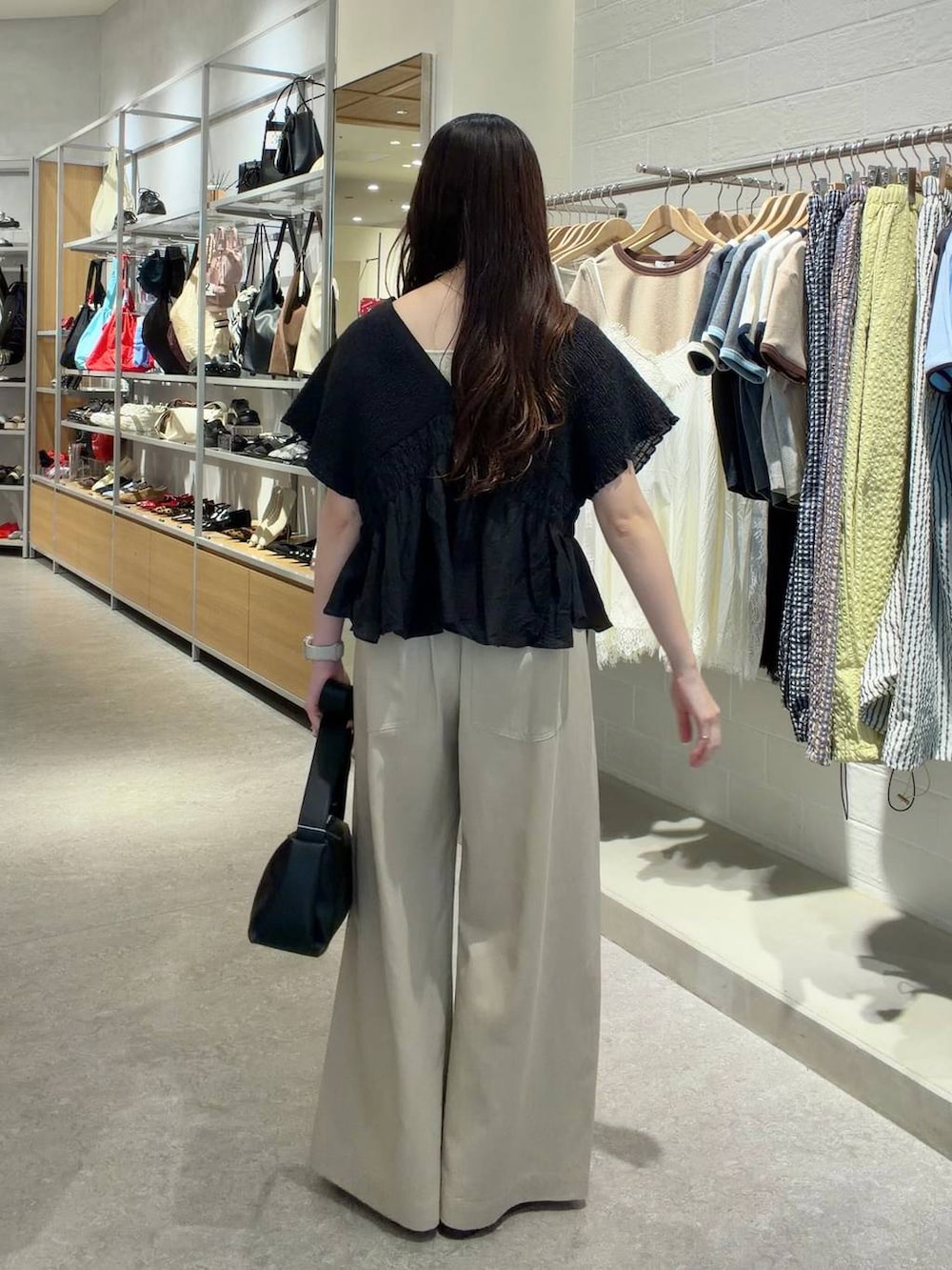 ゴールド系のタンクトップ、ベージュ系のデニムパンツ、ブラック系のローファーを着用したレディースの春コーディネートの3枚目の写真
