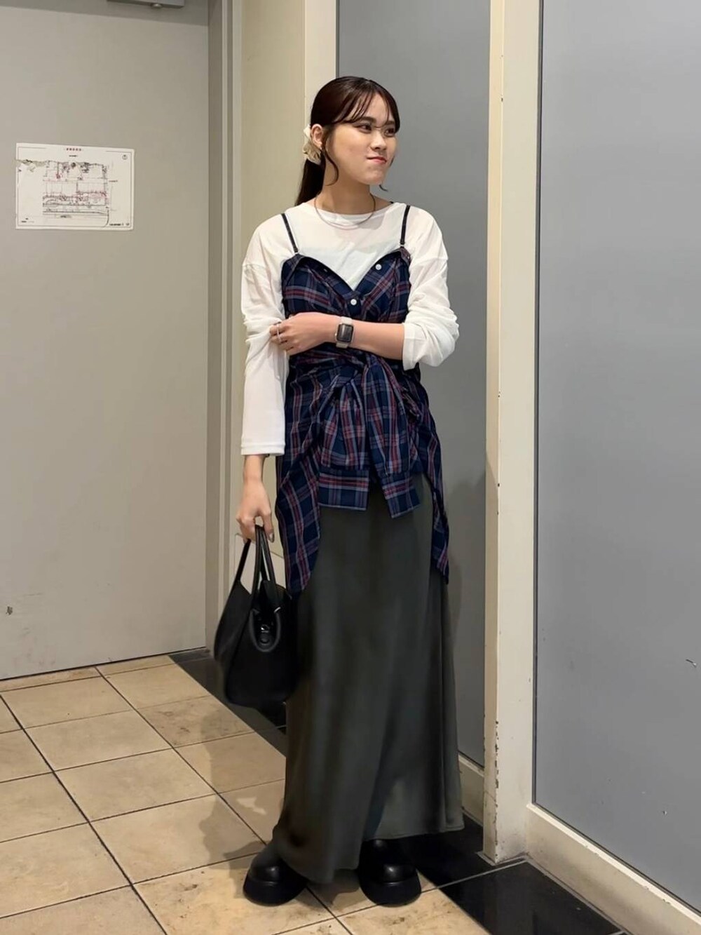 グレー系のスカート、ブラック系のショルダーバッグ、ブラック系のサンダルを着用したレディースの秋コーディネートの5枚目の写真