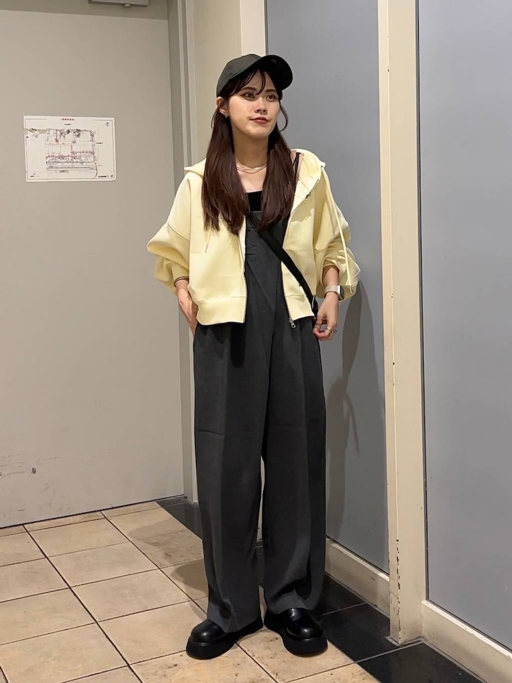 グレー系のサロペット/オーバーオール、ブラック系のショルダーバッグ、ブラック系のキャミソールを着用したレディースの秋コーディネートの4枚目の写真