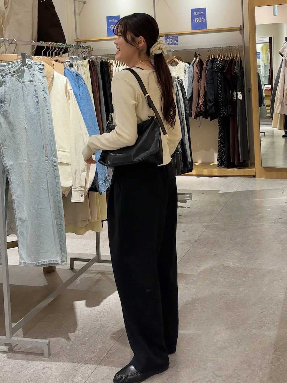 ブラック系のスウェットパンツ、ブラック系のショルダーバッグ、ブラック系のローファーを着用したレディースの春コーディネートの6枚目の写真