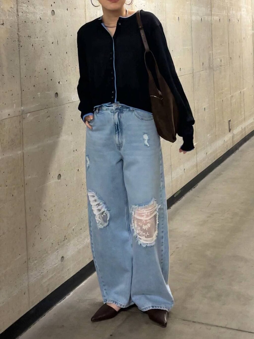 ブルー系のデニムパンツ、ブラウン系のショルダーバッグ、ブラック系のカーディガン/ボレロを着用したレディースの春コーディネートの4枚目の写真