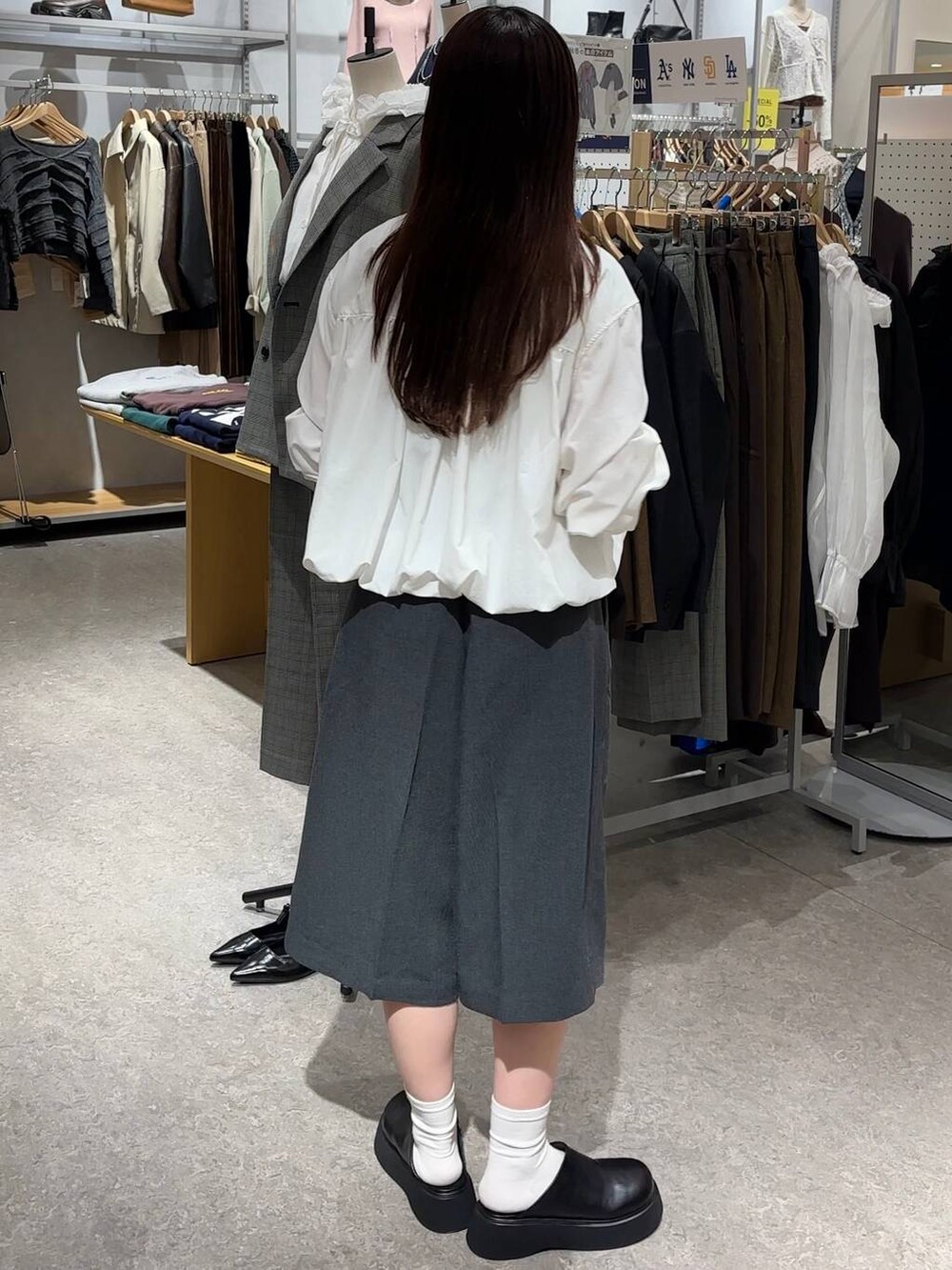 グレー系のその他パンツ、ブラック系のサンダル、ホワイト系のシャツ/ブラウスを着用したレディースの秋コーディネートの4枚目の写真