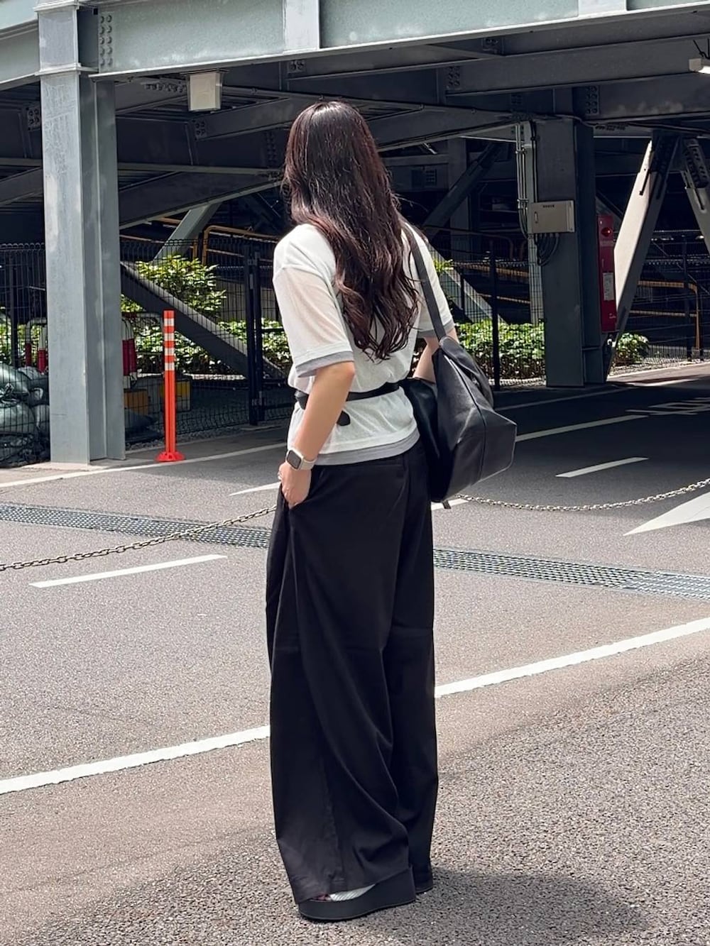 ブラック系のスラックス、シルバー系のサンダル、ホワイト系のTシャツ/カットソーを着用したレディースの春コーディネートの2枚目の写真