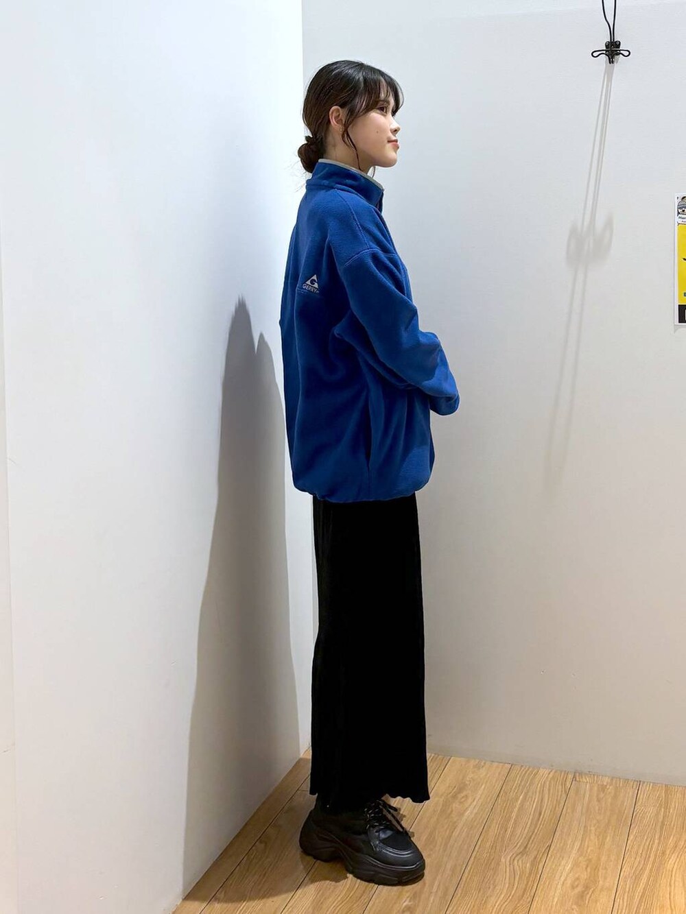 ブラック系のスカート、ブルー系のTシャツ/カットソー、ブラック系のスニーカーを着用したレディースの秋コーディネートの3枚目の写真