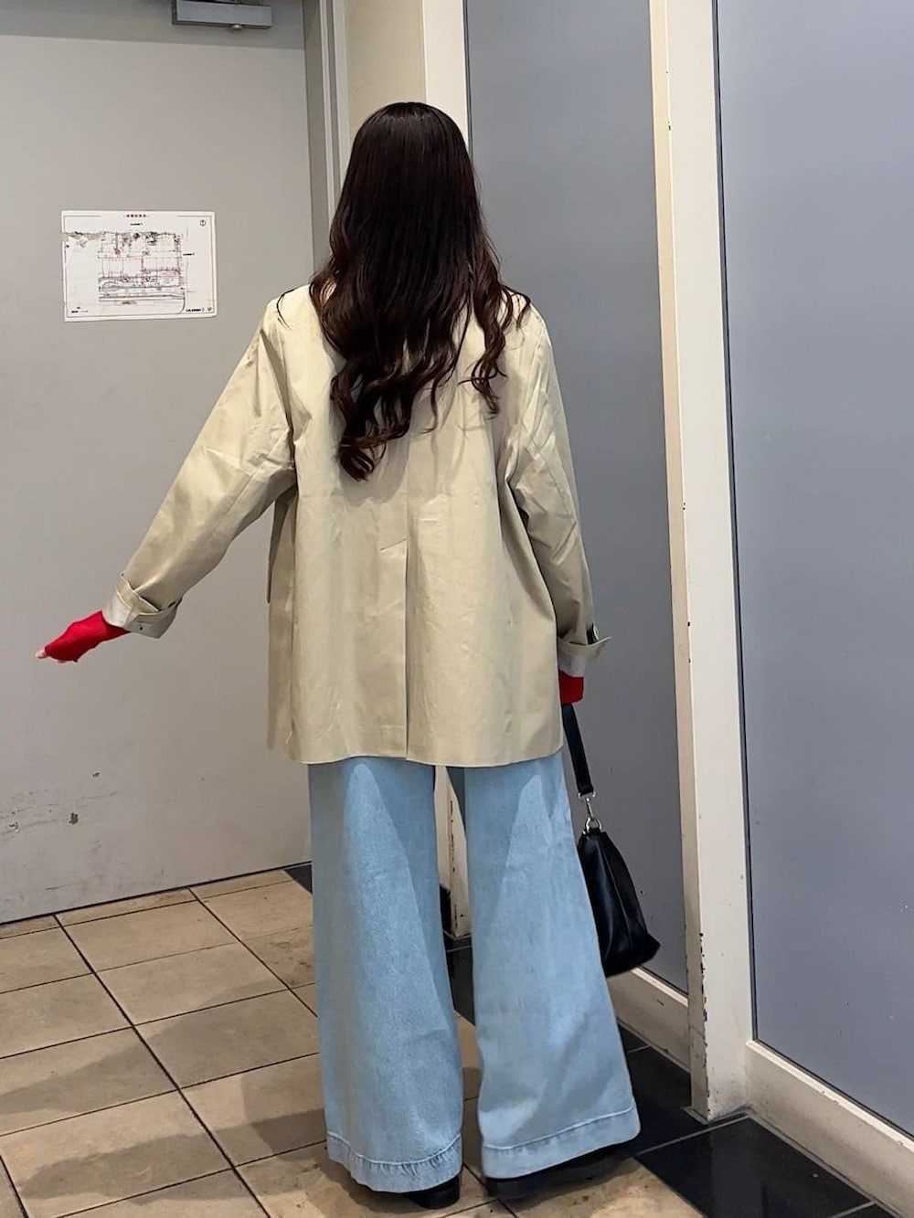 ブラック系のローファー、ブルー系のデニムパンツ、ブラック系のショルダーバッグを着用したレディースの冬コーディネートの3枚目の写真