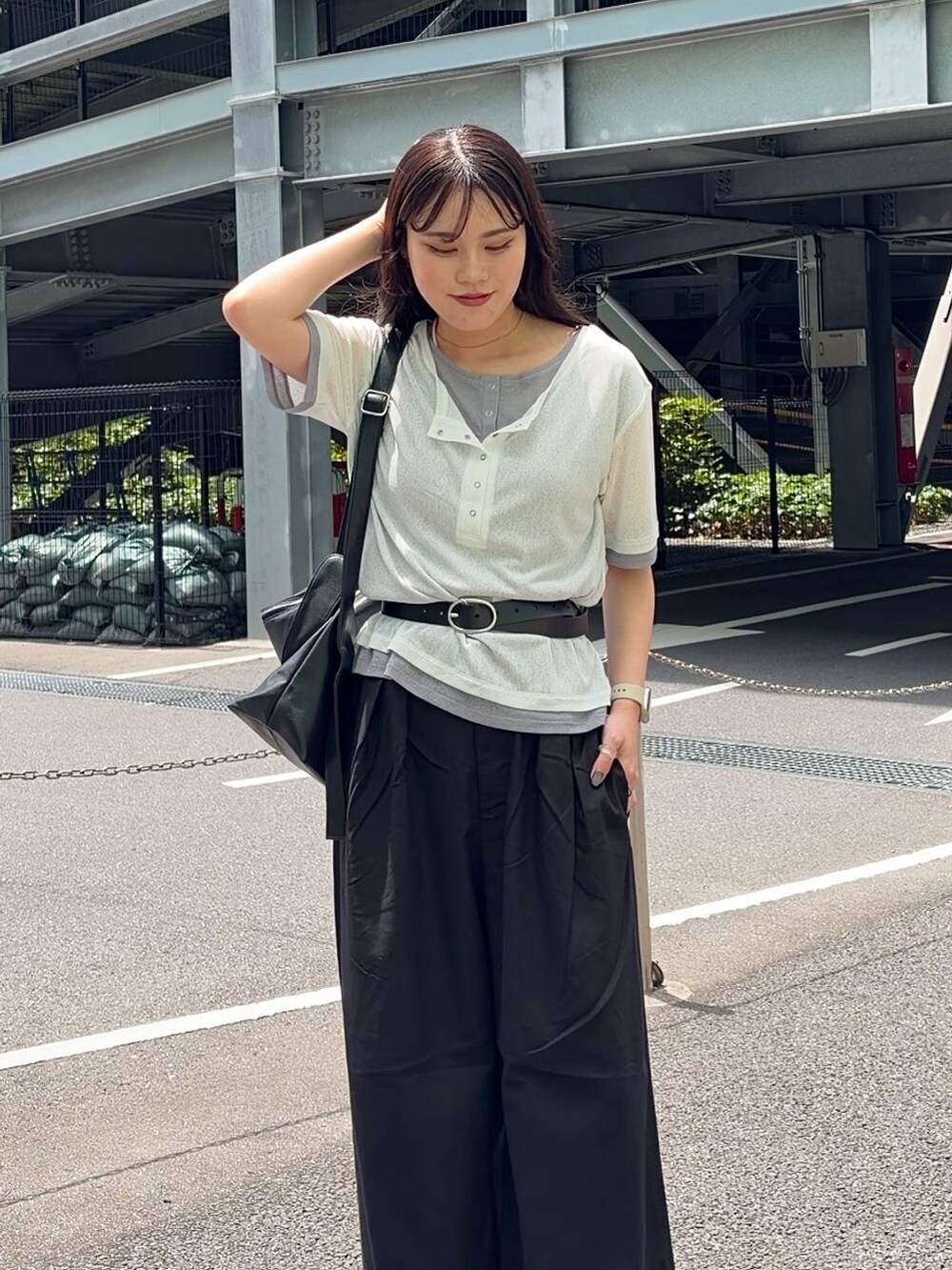 ブラック系のスラックス、シルバー系のサンダル、ホワイト系のTシャツ/カットソーを着用したレディースの春コーディネートの4枚目の写真