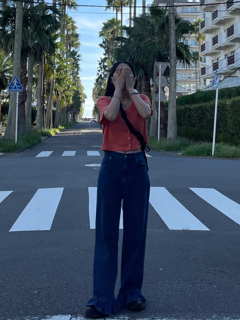 ブラック系のサンダル、ブルー系のデニムパンツ、ブラック系のショルダーバッグを着用したレディースの秋コーディネートの2枚目の写真