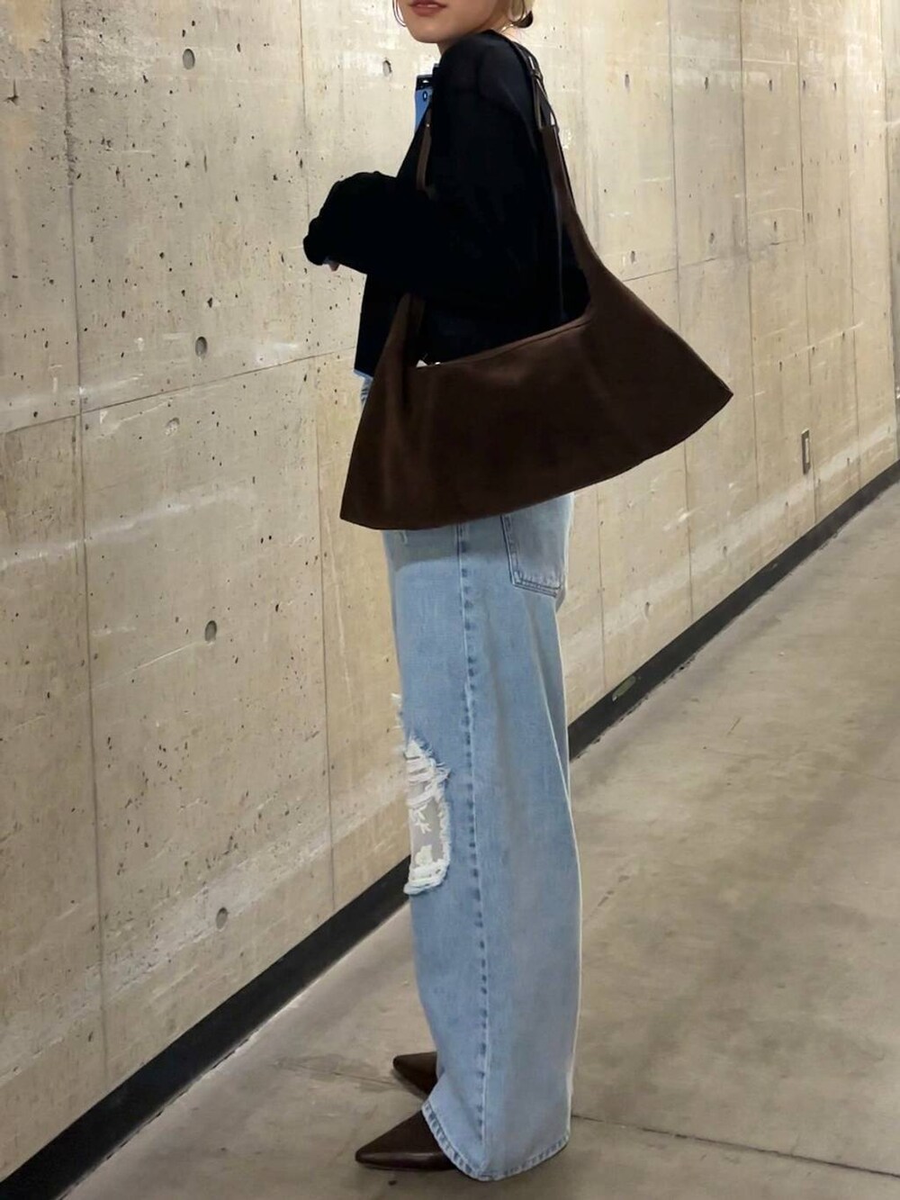 ブルー系のデニムパンツ、ブラウン系のショルダーバッグ、ブラック系のカーディガン/ボレロを着用したレディースの春コーディネートの7枚目の写真