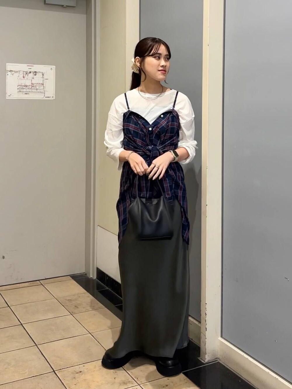 グレー系のスカート、ブラック系のショルダーバッグ、ブラック系のサンダルを着用したレディースの秋コーディネートの6枚目の写真