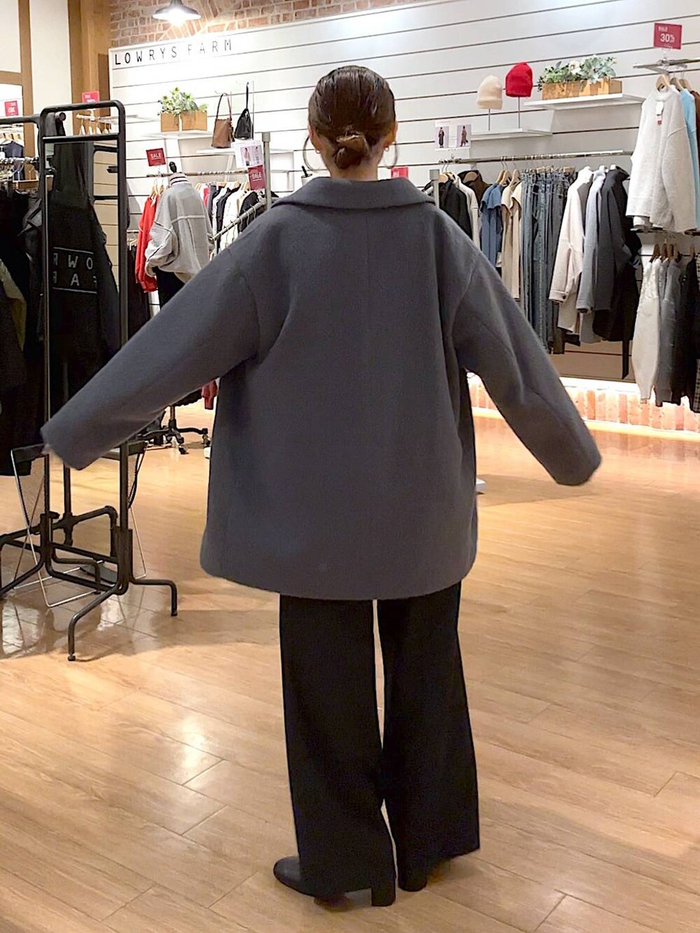 レッド系のニット/セーター、ブラック系のブーツ、ブラック系のその他パンツを着用したレディースの冬コーディネートの4枚目の写真